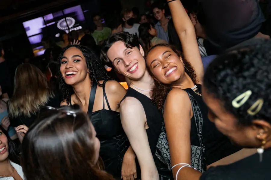 Three students smiling at a nightclub