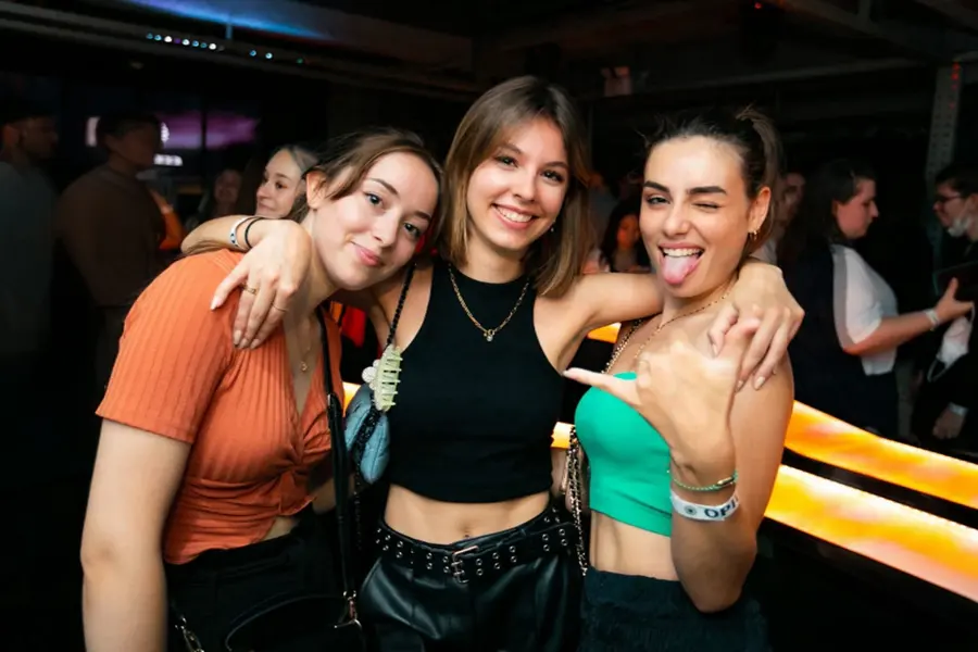 Three students posing together at a Student Night Out party